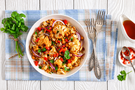 Roasted cauliflower and chickpea bowl with red bell pepper, red onion, coriander and grains