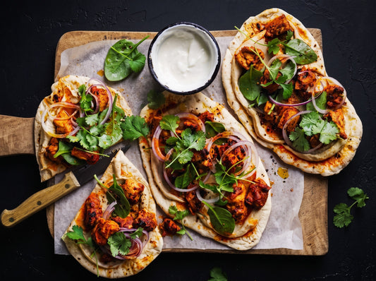 Smoky tandoori chicken flatbreads with yogurt, red onion, coriander and fresh greens